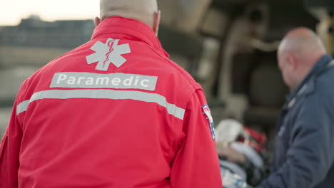 paramedic, ambulance and man with first aid