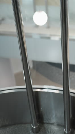 una hermosa vista desde un ascensor, capturando los alrededores a través de las paredes de vidrio. la imagen muestra el diseño arquitectónico moderno y la iluminación ambiental del edificio