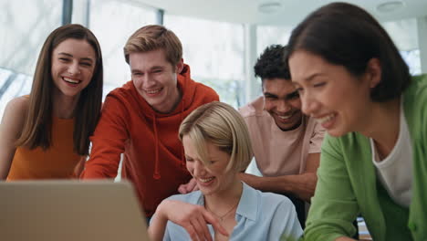 startup agency team laughing laptop at workplace closeup. happy group having fun