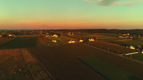 Una-Vista-Aérea-De-Campos-De-Maíz-Y-Tierras-De-Cultivo-Y-Granjas-Fértiles-En-La-Hora-Dorada-En-Un-Día-Soleado-De-Verano