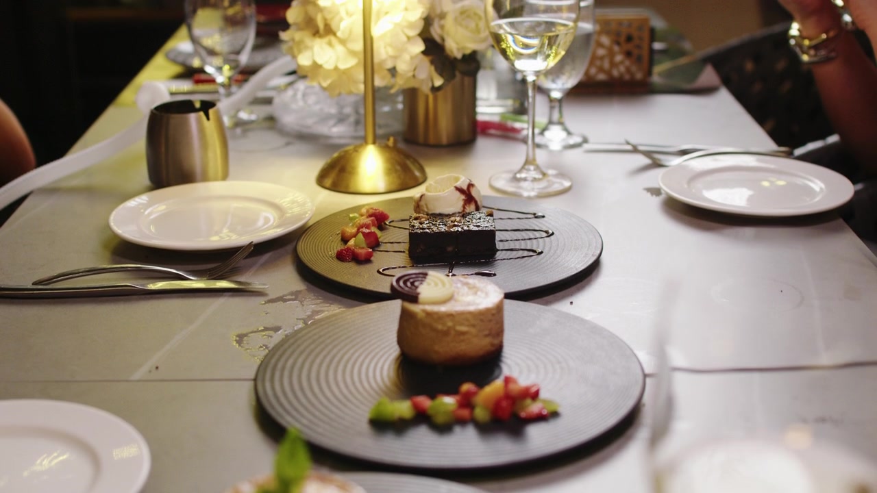 Elegant plated desserts arranged on a restaurant table with ambient lighting