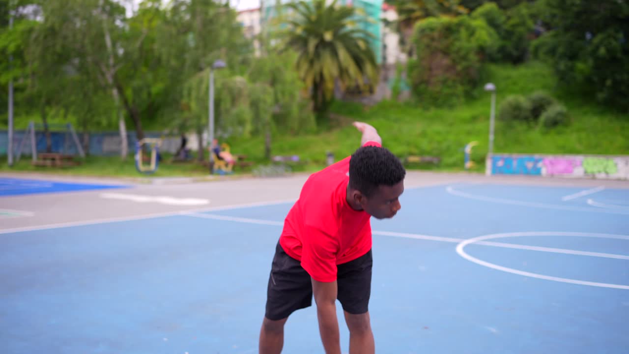 A young man exercising on a basketball court
