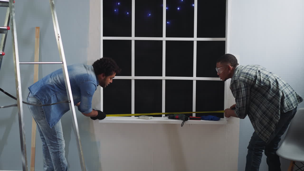 Black employees measure window width with retractable tape