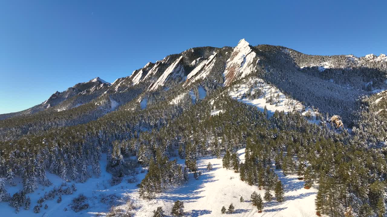 órbita aérea de los famosos flatirons cubiertos de nieve durante el invierno en boulder, colorado, ee.uu.