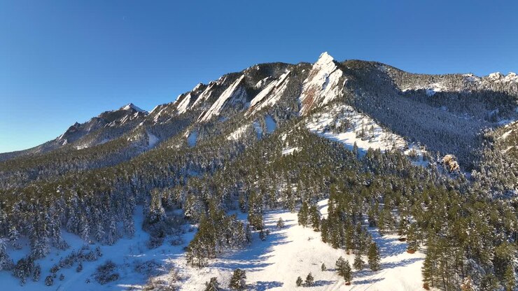 Orbita aerea dei famosi Flatirons coperti di neve durante l'inverno a Boulder, Colorado, USA
