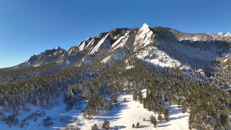 aerial orbit of the famous flatirons covered in snow during winter in boulder, colorado, usa