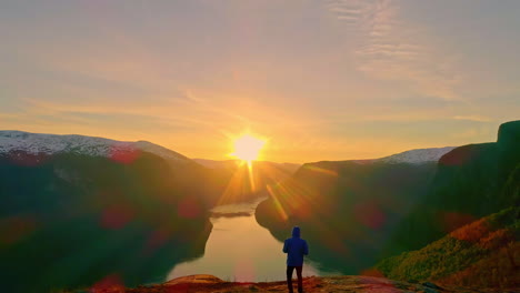 man walking towards sun on the mountain