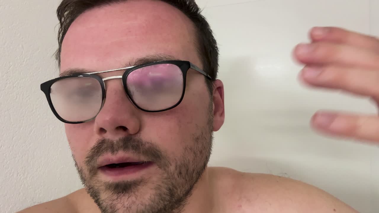 Man with foggy eyeglasses caused by humidity and temperature change, a common everyday moment