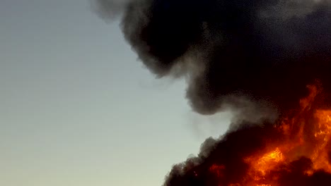 huge dangerous raging fire burns rapidly sending thick black flames into the sky