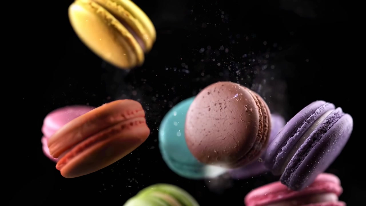 Colorful French Macarons Falling in Slow Motion on Black Background