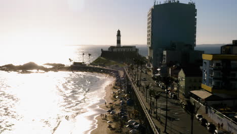 Aerial-view-of-Farol-da-Barra,-the-sea-and-the-neighborhood-around,-Salvador,-Bahia,-Brazil