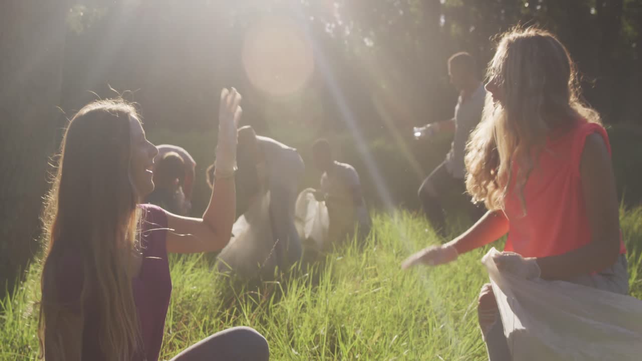 средний взрослый волонтер и делает высокий пять во время дня очистки реки