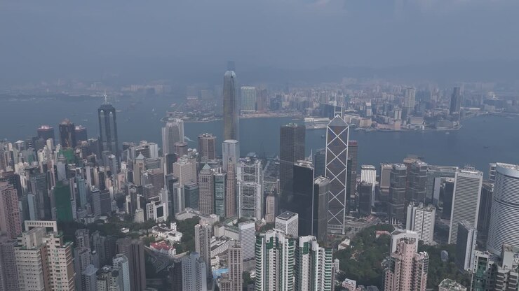 Deslumbrante vista aérea diurna de Hong Kong capturada por drone. Arranha-céus, porto e paisagem urbana panorâmica de cima. Filmagem perfeita que mostra o horizonte urbano e o cenário vibrante à beira-mar.