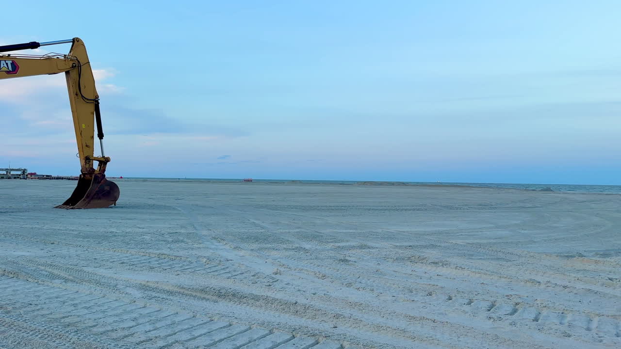 Panning view, excavator on beach during sand replenishment reclaim