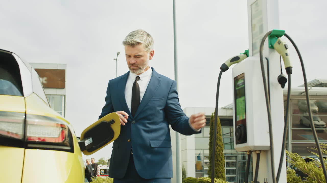 전기 차량을 충전하는 사업가