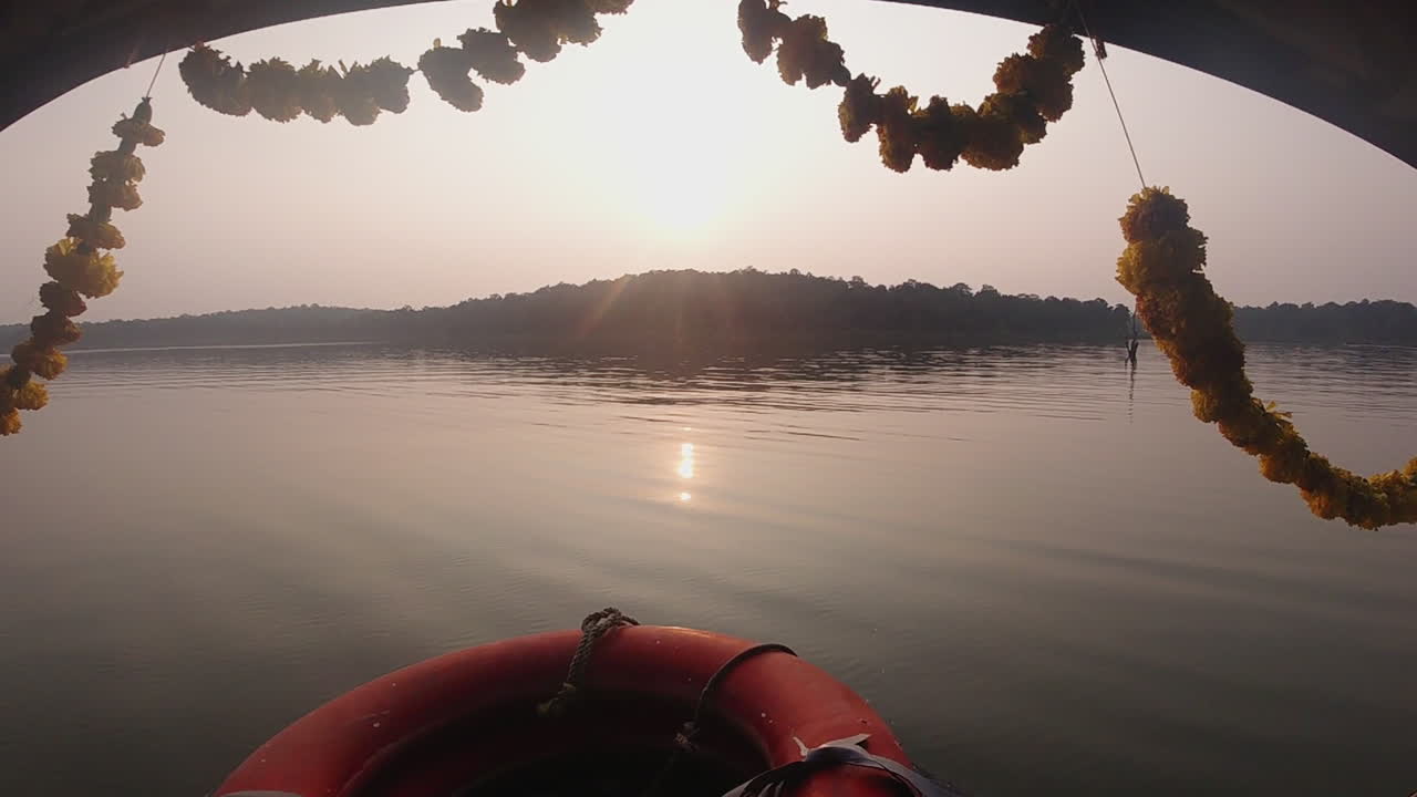 Serene boat ride on Kabini River, with sunset light reflecting over still waters