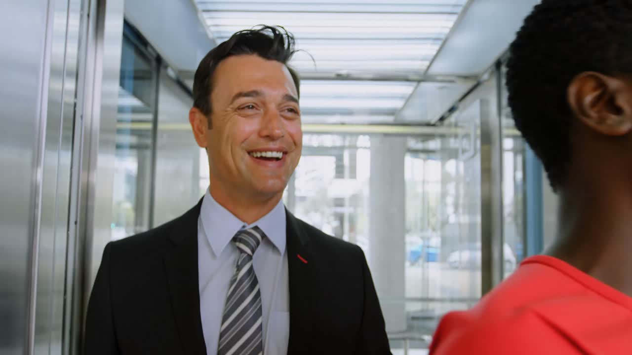 사업가와 사업가 여성이 엘리베이터에서 나온다 4k