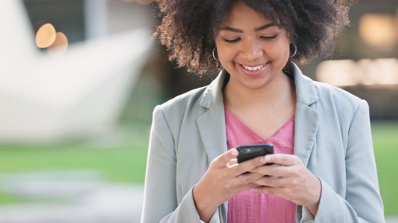 Happy female texting on a phone outside