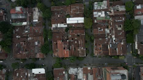 aerial top shot of medellín’s rooftops and street grid, showcasing urban charm and bustling life, dense textured backdrop