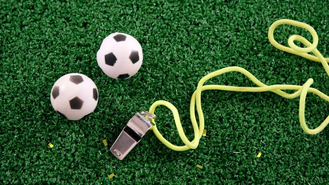 Animazione di coriandoli dorati che cadono su un pallone da calcio e un fischietto