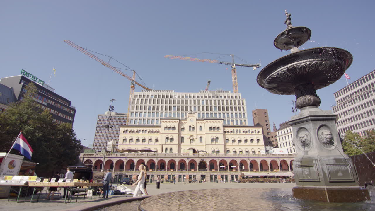 View from Young's Square on Torggata street of cranes behind building, slowmo
