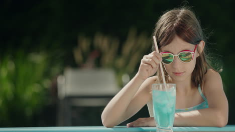 Teenage-girl-crushes-ice-in-a-cocktail-on-the-side-of-the-pool