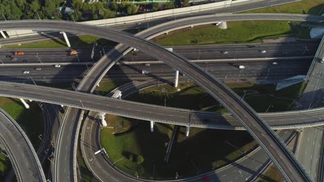 multi-level road interchange and cars traffic. drone is flying forward, camera is tilting down. aerial view.