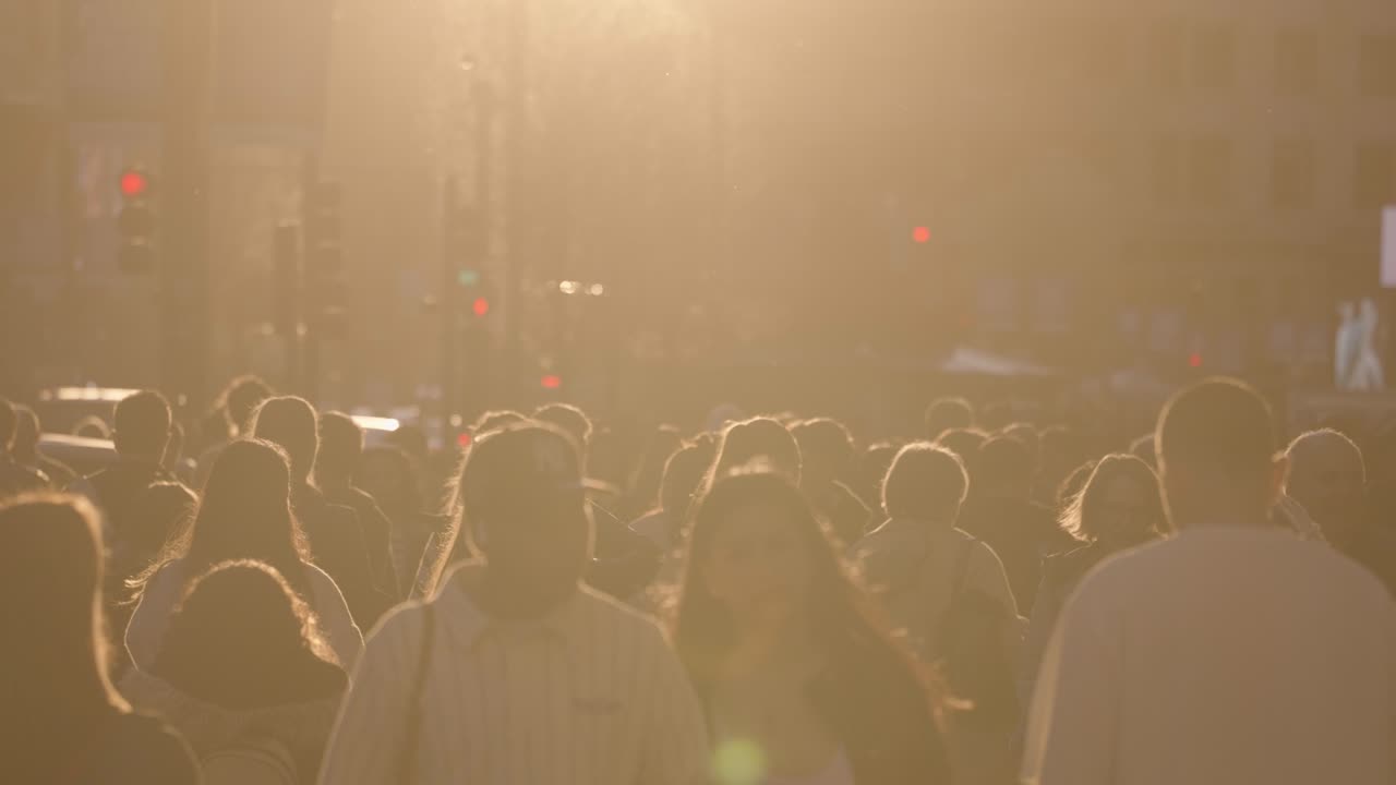Crowd of people walking in a city street at sunset
