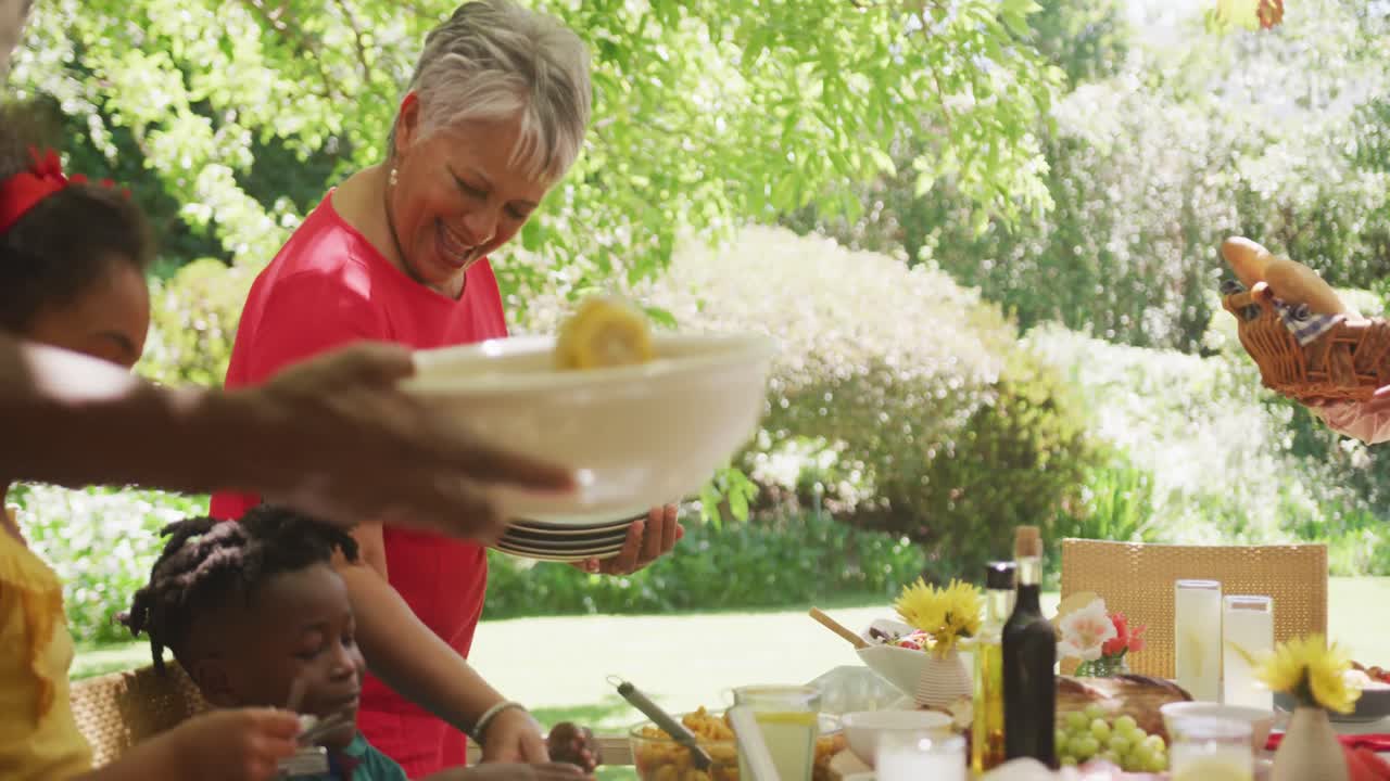 여러 세대의 아프리카계 미국인 가족이 함께 정원에서 시간을 보내고 있습니다.