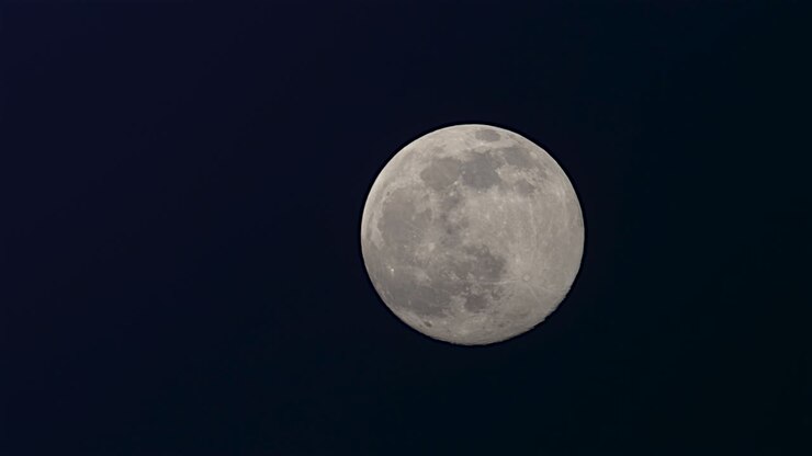 Lua Cheia no céu noturno escuro de inverno de fevereiro com algumas nuvens passando