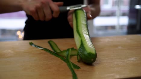 Koch-Schält-Frische-Gurke-In-Der-Küche.-Nahaufnahme