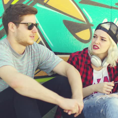 young hipster urban couple relaxing on a sidewalk