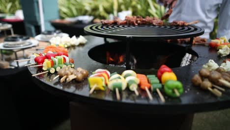 chef putting meat on round grill with vegetables