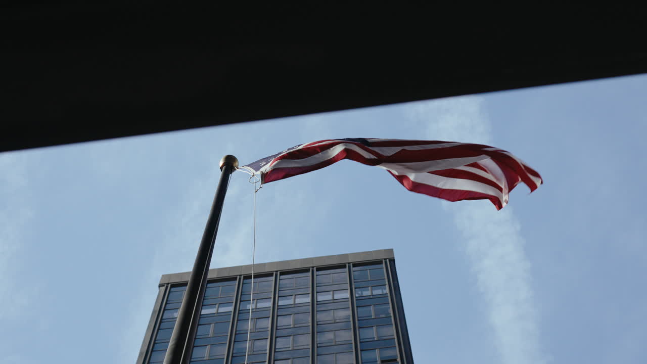 American Flag Waving Above a Skyscraper