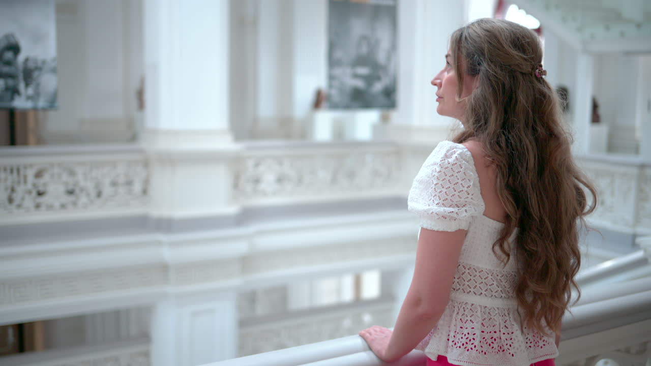 Woman visiting an art museum, admiring paintings