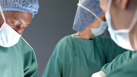 Diverse-female-and-male-surgeons-in-masks-passing-surgical-tools-during-operation,-slow-motion