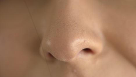 extreme macro close up of a woman's nose while breathing in fresh air