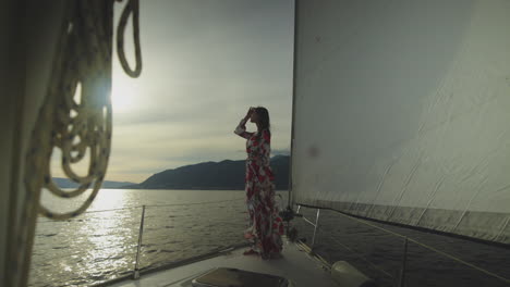 woman in a floral dress on a sailboat during sunset