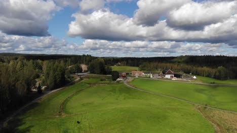 drone footage over green field and farm in sweden