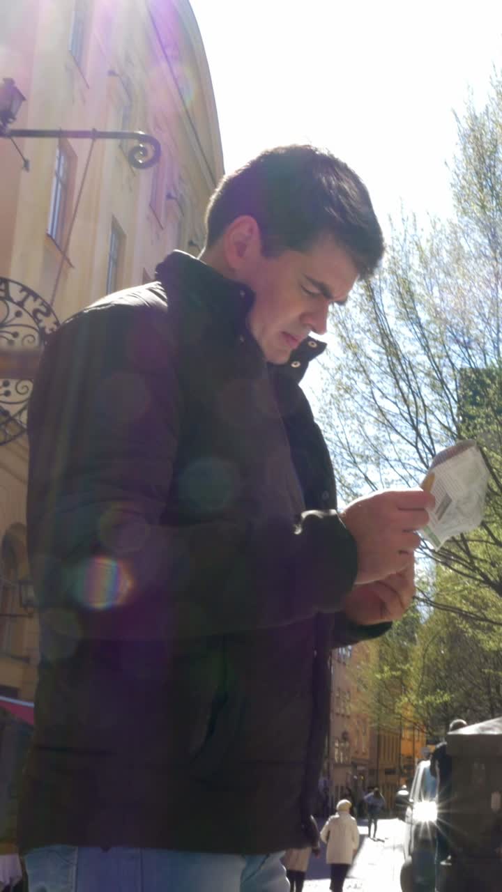 Man reading newspaper on the street