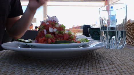 cerca de hombre comiendo auténtica y colorida ensalada vegetariana marroquí
