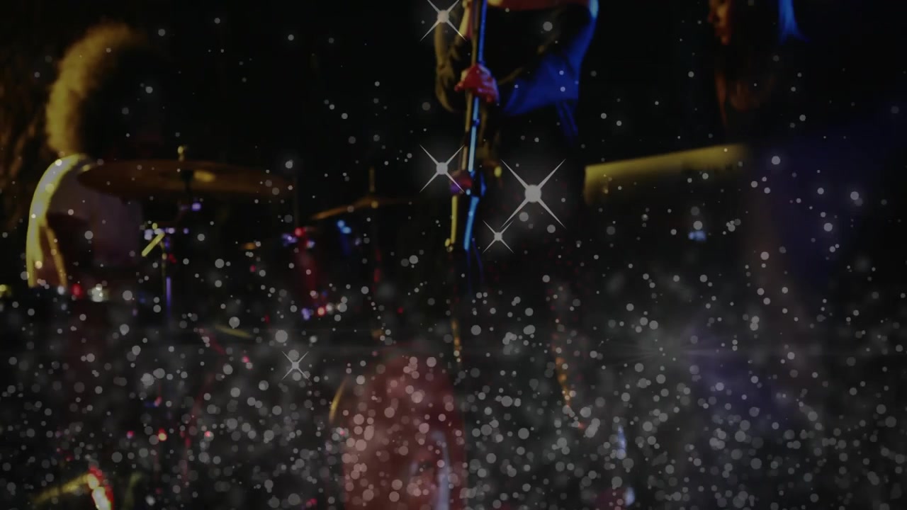 Band leaning over mixer while camera refocusing, revealing crew through bokeh during music set