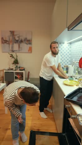 couple cleaning dishes in kitchen