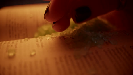 hand sprinkling bath salt on open book