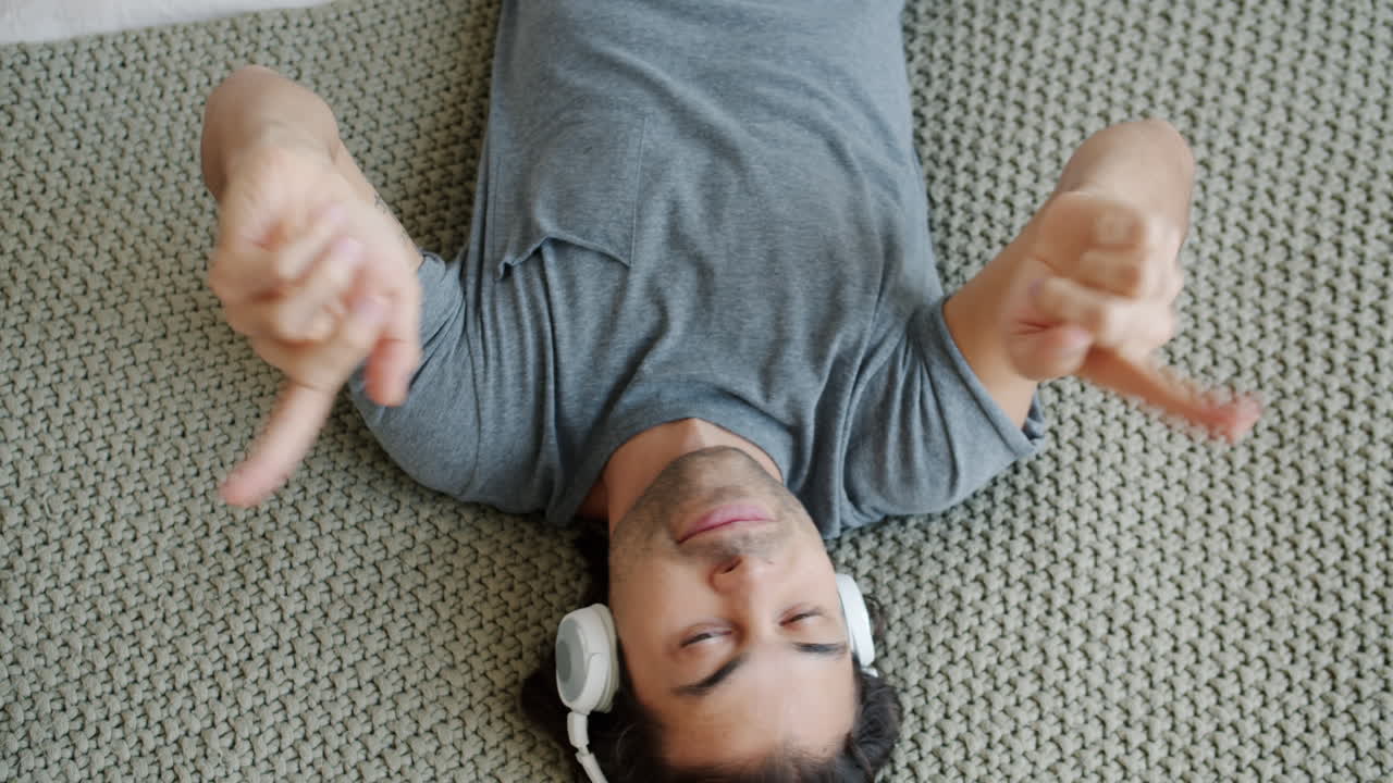 Man listening to music on headphones while lying down
