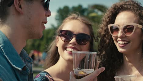 group of friends spending time together at music festival and drinking beer.