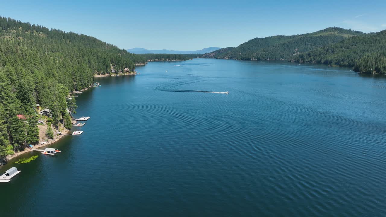Wide aerial view of Spirit Lake in Idaho with a boat creating wakes on a summer day