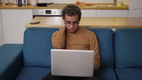 overhelmed young man using laptop on the sofa