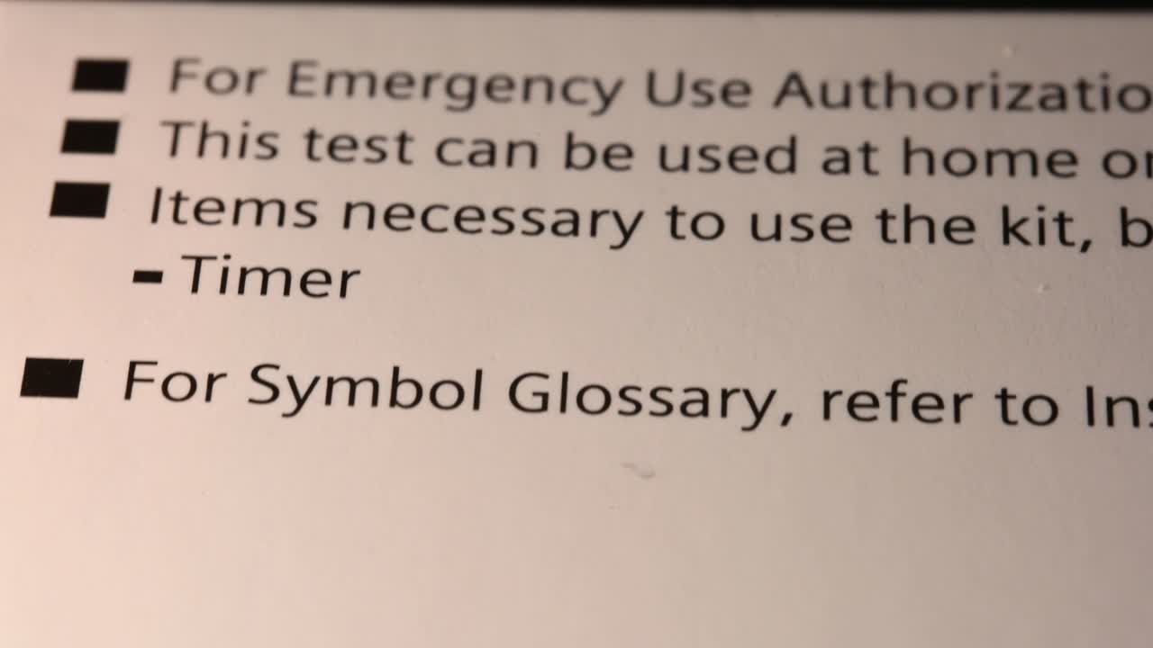 leyendo la parte posterior del empaque de prueba casera covid-19