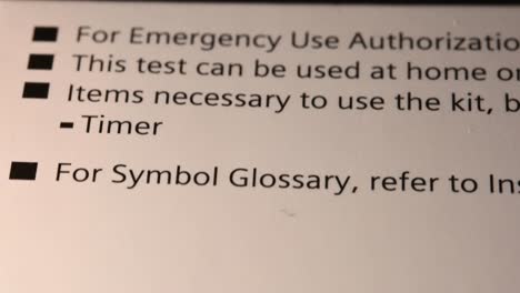 reading up the back of covid-19 home test packaging